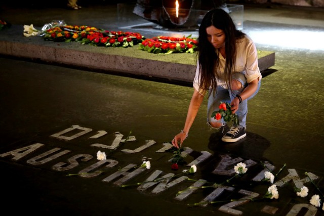 Un familiar de las víctimas del Holocausto israelí establece una flor en la Sala del Recuerdo donde los nombres de los principales campos de exterminio y de concentración se escriben en una ceremonia por el Día anual de la Memoria del Holocausto en Yad Vashem de Jerusalén el 5 de mayo de 2016. El Estado de Israel se celebra el Día anual conmemorativa de los seis millones de Judios asesinados por los nazis en el Holocausto durante la Segunda Guerra Mundial. GALI Tibbon / AFP