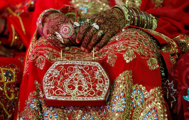 Una novia tiene su bolso durante una ceremonia de boda masiva en Karachi, Pakistán 9 de mayo de 2016. REUTERS / Akhtar Soomro