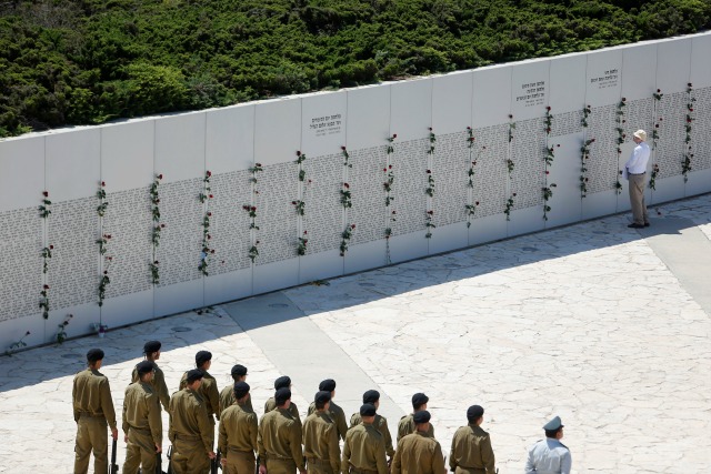 Un hombre mira a una pared conmemorativa, grabado con los nombres de los soldados caídos de los cuerpos blindados, durante una ceremonia del Memorial Day en Latrun cerca de Jerusalén 11 de mayo de 2016. REUTERS / Nir Elias
