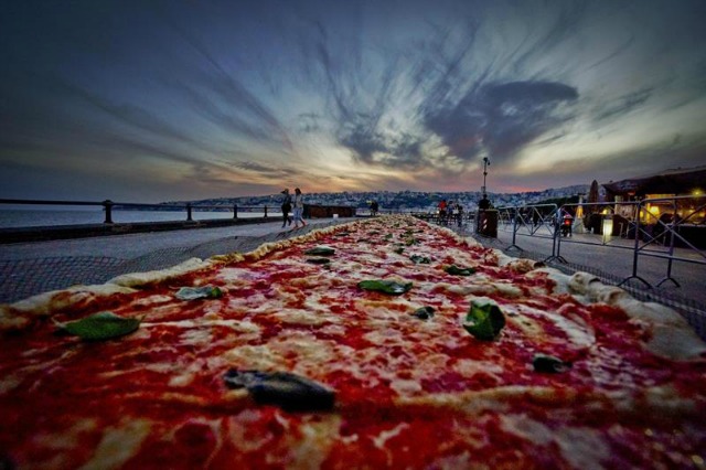 Fotografía facilitada hoy, 19 de mayo de 2016 de una pizza napolitana de dos kilómetros de largo, elaborada para batir el récord del mundo, y colocada a lo largo del paseo marítimo en Nápoles (Italia) ayer. EFE/Ciro Fusco