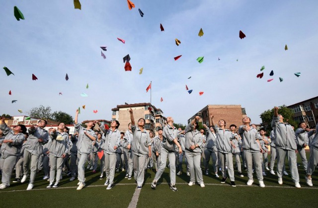 Esta foto tomada el 24 de mayo, el año 2016 muestra a los estudiantes de alto nivel que vuelan aviones de papel para liberar el estrés ante los exámenes de ingreso a la universidad en una escuela secundaria en Handan, provincia de Hebei, norte de China. Los tres días de prueba de acceso a la universidad 2016 se iniciará el 7 de junio. STR / AFP