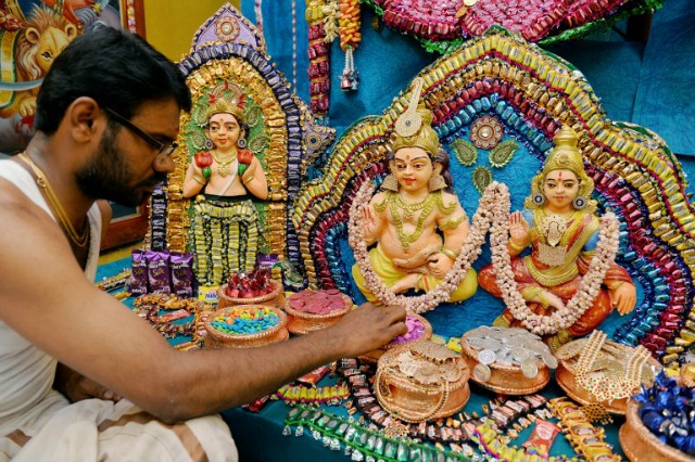 Un sacerdote indio decora ídolos hindúes de dioses y diosas con caramelo y chocolates en el templo Kadambaranya Ashram en Bangalore el 6 de junio de 2016. Las deidades están decoradas con los dulces en la ocasión de su fundador el cumpleaños de Krishnaalwar Swamigal cada año. Manjunath Kiran / AFP