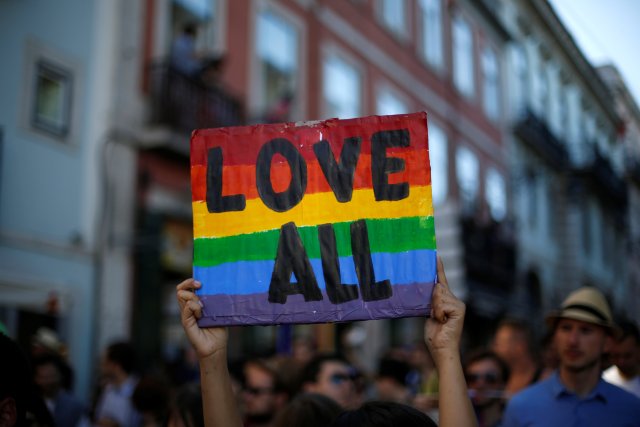 A participant holds up a sign while marching during a Gay Pride Parade in downtown Lisbon, Portugal June 18, 2016.  REUTERS/Rafael Marchante
