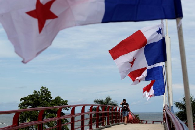 A woman walk pass next to Panama flags a day before the inauguration of the Panama Canal Expansion project, in Panama City, Panama June 25, 2016. REUTERS/Carlos Jasso