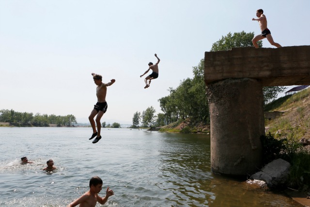 Muchachos saltan en un lago, se encuentra en una isla en el medio del río Yenisei, en un día caluroso de verano en la ciudad siberiana de Krasnoyarsk, Rusia, 28 de junio de 2016. REUTERS / Ilya Naymushin