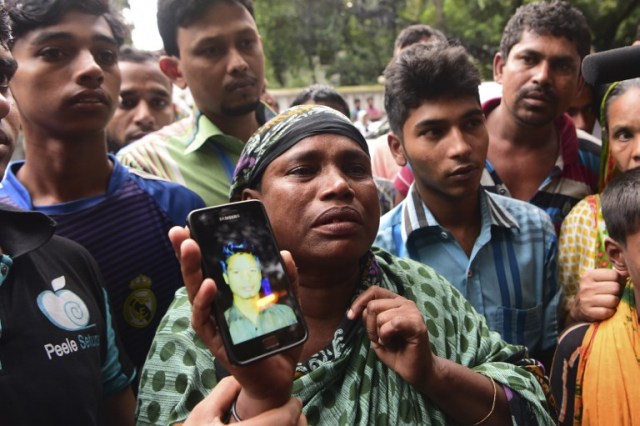A Bangladeshi woman holds a photograph of her son, who worked at a cafe that was the scene of an attack and seige, and who is missing, in Dhaka on July 3, 2016. Bangladesh said July 3 the attackers who slaughtered 20 hostages at a restaurant were well-educated followers of a homegrown militant outfit who found extremism "fashionable", denying links to the Islamic State group. As the country held services to mourn the victims of the siege in Dhaka, details emerged of how the attackers spared the lives of Muslims while herding foreigners to their deaths. / AFP PHOTO / APF / STR