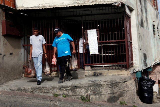 Residentes salen de un centro comunitario con bolsas de alimentos que compraron a bajo precio REUTERS/Carlos Jasso