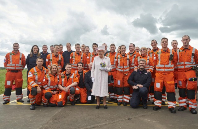 La reina Isabel II de Gran Bretaña (C) posa para fotos con miembros de la tripulación durante una visita a East Anglia ambulancia de aire (EAAA) en el aeropuerto de Cambridge, en el este de Inglaterra, el 13 de julio de 2016. NIKLAS HALLE'N / POOL / AFP