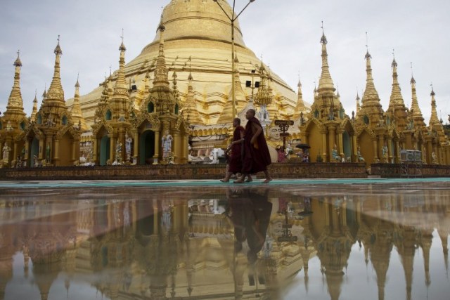 Buddhist monks visit Myanmar's landmark Shwedagon Pagoda in Yangon on July 14, 2016. Around 89 percent of the population in Myanmar practice Buddhism, with the rest divided among Christians and Muslims. / AFP PHOTO / YE AUNG THU