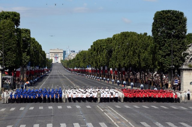 French students stand as they sing the French National anthem on the Place de la Concorde after marching down the Champs-Elysees avenue during the annual Bastille Day military parade in Paris on July 14, 2016. France holds annual Bastille Day military parade with troops from Australia and New Zealand as special guests among the 3,000 soldiers who will march up the Champs Elysees avenue. They will be accompanied by 200 vehicles with 85 aircraft flying overhead. / AFP PHOTO / DOMINIQUE FAGET