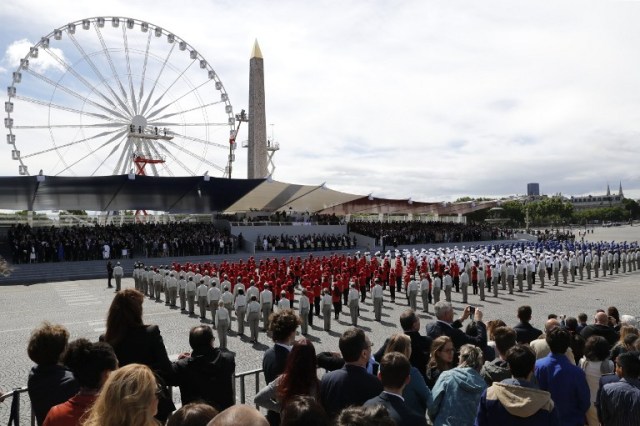 French students sing the French National anthem in front of the presidential box on the Place de la Concorde after marching down the Champs-Elysees avenue during the annual Bastille Day military parade in Paris on July 14, 2016. France holds annual Bastille Day military parade with troops from Australia and New Zealand as special guests among the 3,000 soldiers who will march up the Champs-Elysees avenue. They will be accompanied by 200 vehicles with 85 aircraft flying overhead. / AFP PHOTO / PATRICK KOVARIK