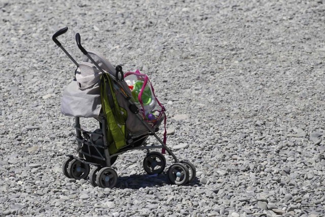 An abandonned baby stroller is seen on the beach near the scene where a truck ran into a crowd at high speed killing scores and injuring more who were celebrating the Bastille Day national holiday, in Nice, France, July 15, 2016. REUTERS/Pascal Rossignol