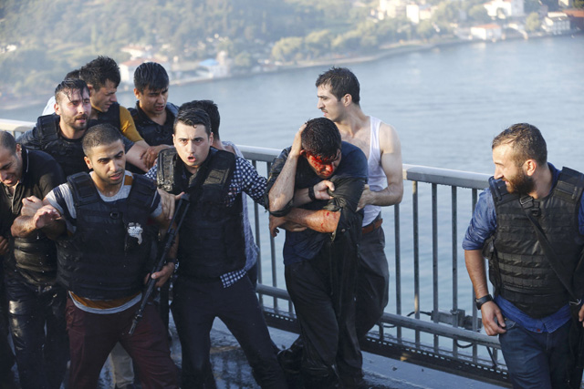 Policemen protect a soldier (C, R) from the mob after troops involved in the coup surrendered on the Bosphorus Bridge in Istanbul, Turkey July 16, 2016. REUTERS/Murad Sezer TPX IMAGES OF THE DAY