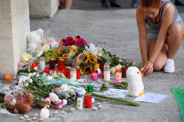 Una mujer enciende velas en Yverdon-les-Bains, Suiza hoy 18 de julio de 2016, en tributo a las 84 víctimas del atentado de Niza durante el día de la Bastilla el pasado 14 de Julio. EFE/Laurent Gillieron