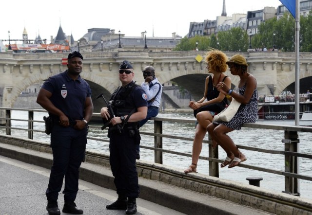Policemen stand in "Paris Plage" (Paris Beach) during the opening day of the event on the bank of the Seine river, in central Paris, on July 20, 2016. The 15th edition of Paris Plage will run until September 4, 2016. / AFP PHOTO / BERTRAND GUAY
