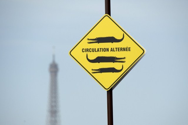 A picture taken in "Paris Plage" (Paris Beach) on the bank of the Seine river, in central Paris, on July 20, 2016 shows a sign reading "alternate traffic". The 15th edition of Paris Plage will run until September 4, 2016. / AFP PHOTO / BERTRAND GUAY