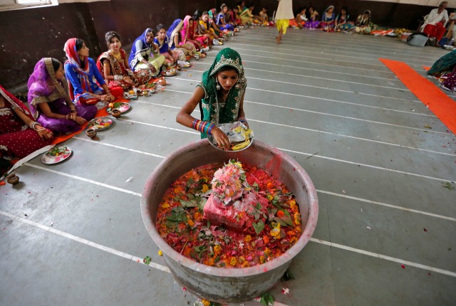 Una niña pone incienso en Shivling (un símbolo del dios Shiva) en el último día del festival de Jaya Parvati Vrat en un templo en Ahmedabad, India, 21 de julio de 2016. REUTERS / Dave Amit
