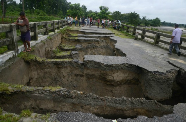 pueblo indio miran un puente dañado por las lluvias torrenciales en el pueblo de Toribari en las afueras de Siliguri de julio 21,2016. las constantes precipitaciones en las últimas 48 horas ha causado inundaciones con varios deslizamientos de tierra en las colinas cercanas de Siliguri y áreas adyacentes del norte de Bengala. DIPTENDU DUTTA / AFP