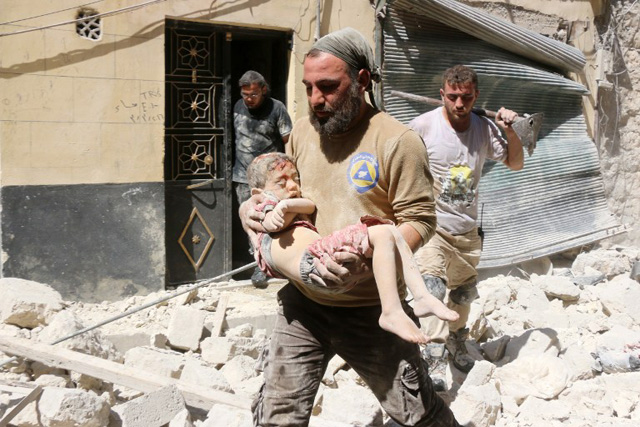 EDITORS NOTE: Graphic content / A Syrian civil defence worker carries the body of a child following reported air strikes on July 17, 2016 in the rebel-controlled neighbourhood of Maysar in the northern Syrian city of Aleppo. Opposition-controlled parts of Syria's battered northern city Aleppo came under total siege, after government forces severed the last route out of the east. An estimated 300,000 civilians live in rebel-held neighbourhoods of Syria's second city, according to the United Nations, and there are fears that they could face starvation. / AFP PHOTO / THAER MOHAMMED