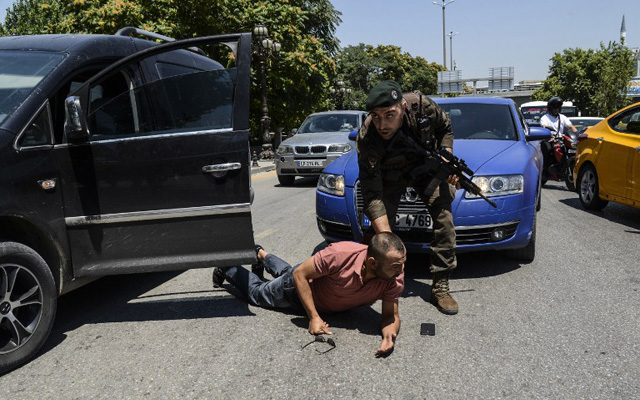 EDITORS NOTE: Graphic content / A Turkish police restrains a man on the ground during an operation in front of the courthouse on July 18, 2016, in Ankara. Turkey has detained more than 7,500 suspects involved in the coup plot seeking to oust the government, the prime minister said on July 18, 2016. Giving a new toll, he said 208 people were killed by the coup bid, including 145 civilians, 60 police and three soldiers. 1,491 were wounded, he added, In addition, the authorities have said more than 100 coup plotters were killed. / AFP PHOTO / ILYAS AKENGIN