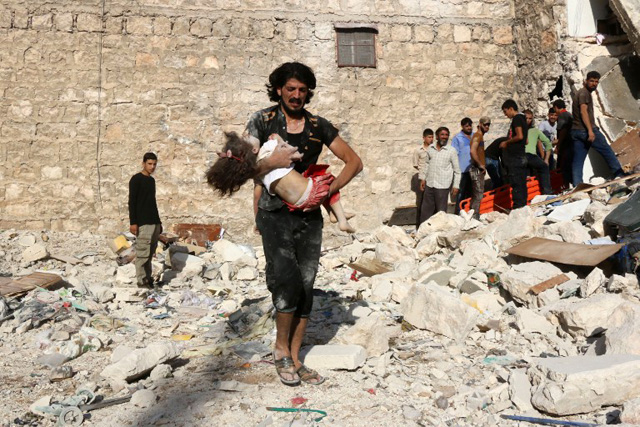 A Syrian man carries a child who was retrieved under the rubble of a collapsed building following a reported air strike on the rebel-held neighbourhood of Sakhur in the northern city of Aleppo on July 19, 2016. Civilians in rebel-held parts of Syria's Aleppo expressed fears on July 18, 2016 of a lengthy government siege, as food supplies dwindled after regime troops seized the only road into the city's east. The government advance, which has been backed by a Russian air offensive, is seen as a major setback for opposition forces in Syria's second city. / AFP PHOTO / THAER MOHAMMED