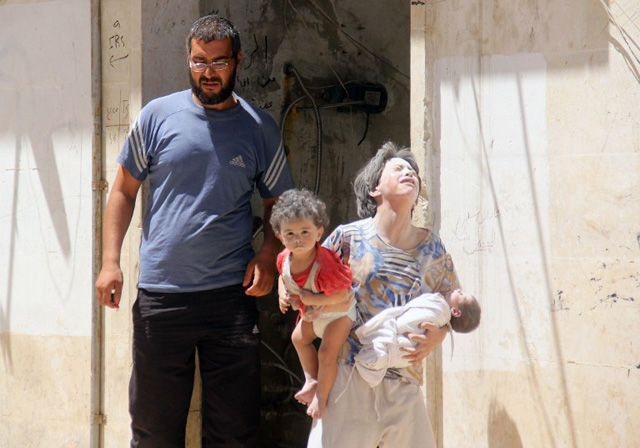 Syrian civilians are seen following a reported air strike by Syrian government forces on the rebel-held northwestern city of Idlib, on July 20, 2016. More than 280,000 people have been killed and millions displaced since Syria's civil war erupted with the brutal repression of anti-government protests in 2011. / AFP PHOTO / Omar haj kadour