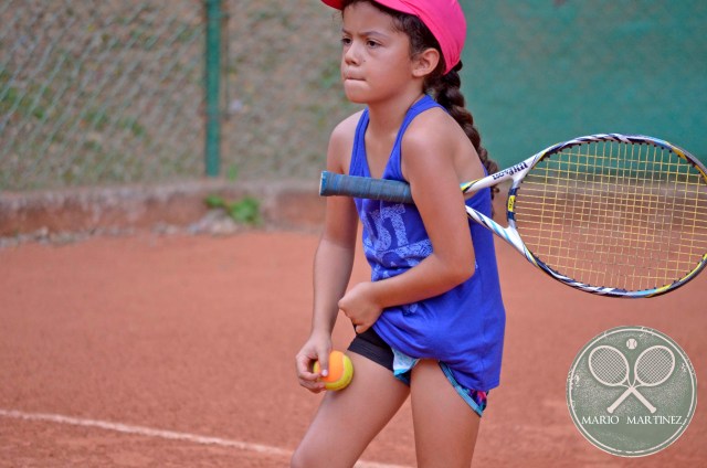 Tenista concetrada en su partido pelota naranja