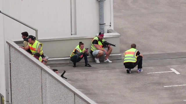 A screen grab taken from video footage shows plain clothes police officers taking cover in the car park of the Olympia shopping mall during shooting rampage in Munich, Germany July 22, 2016. dedinac/Marc Mueller/handout via REUTERS NO ARCHIVES. FOR EDITORIAL USE ONLY. NOT FOR SALE FOR MARKETING OR ADVERTISING CAMPAIGNS. THIS IMAGE HAS BEEN SUPPLIED BY A THIRD PARTY. IT IS DISTRIBUTED, EXACTLY AS RECEIVED BY REUTERS, AS A SERVICE TO CLIENTS. TPX IMAGES OF THE DAY
