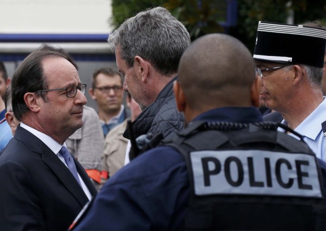 French President Francois Hollande (L) speaks with police forces after two assailants had taken five people hostage in the church at Saint-Etienne-du -Rouvray near Rouen in Normandy, France, July 26, 2016. Two attackers killed a priest with a blade and seriously wounded another hostage in a church in northern France on Tuesday before being shot dead by French police. REUTERS/Pascal Rossignol