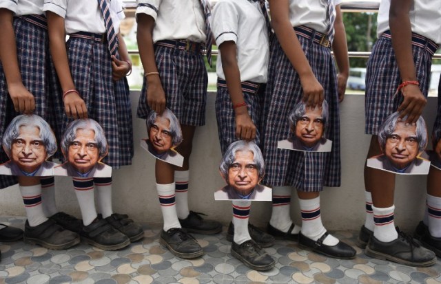 Indian schoolchildren hold masks bearing the image of former Indian president A.P.J Kalam ahead of the first anniversary of his death during a remembrance event at a school in Chennai on July 26, 2016. Former Indian president and Kalam, who played a lead role in the country's nuclear weapons tests, died on July 27, 2015. / AFP PHOTO / ARUN SANKAR
