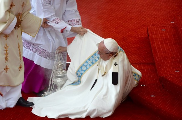 Pope Francis is helped onto his feet after falling on the stairs during a mass at the Jasna Gora Monastery in Czestochowa, Poland on July 28, 2016. Pope Francis visits Poland for an international Catholic youth festival with a mission to encourage openness to migrants. / AFP PHOTO / FILIPPO MONTEFORTE