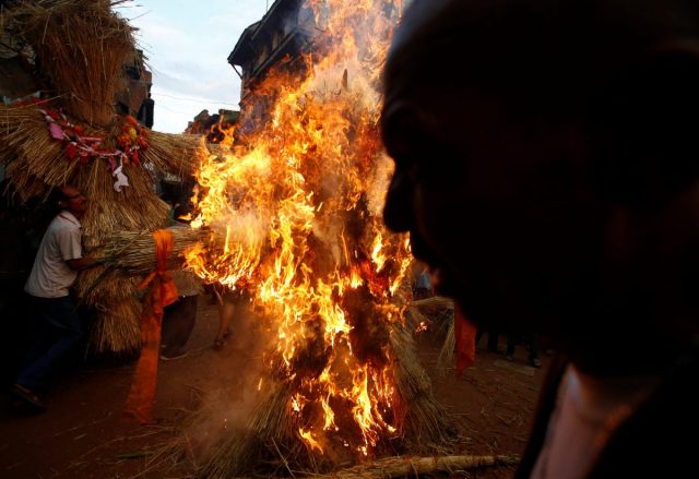 La gente lleva una efigie del demonio Ghantakarna (L) como otra efigie (C) del demonio es quemada para simbolizar la destrucción del mal, durante el festival Ghantakarna en la antigua ciudad de Bhaktapur, Nepal 1 de agosto de 2016. De acuerdo con el folklore local, el demonio Ghantakarna se cree que es "robar" los niños y las mujeres de sus casas y sus barrios. REUTERS/Navesh Chitrakar