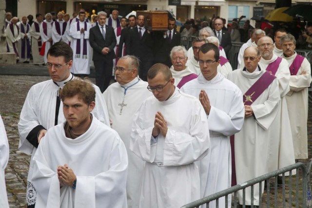 Priests lead a procession as pallbearers carry the coffin of slain French parish priest Father Jacques Hamel to the Cathedral in Rouen, France, August 2, 2016.  Father Jacques Hamel was killed last week in an attack on a church at Saint-Etienne-du-Rouvray near Rouen that was carried out by assailants linked to Islamic State. REUTERS/Jacky Naegelen
