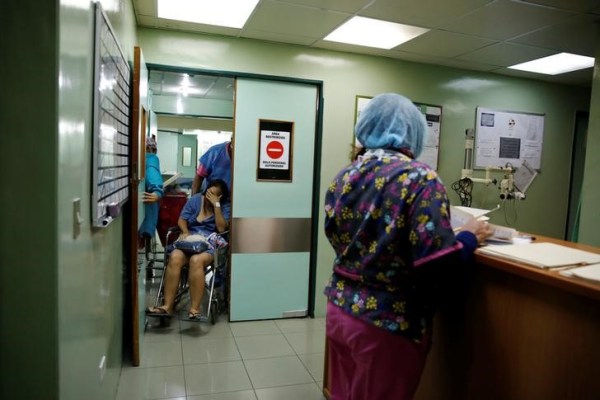 Personal médico traslada a Emileidy Ojeda, de 26 años, en una silla de ruedas luego de una cirugía de esterilización en un hospital en Caracas, Venezuela, 27 de julio de 2016. REUTERS/Carlos Garcia Rawlins.