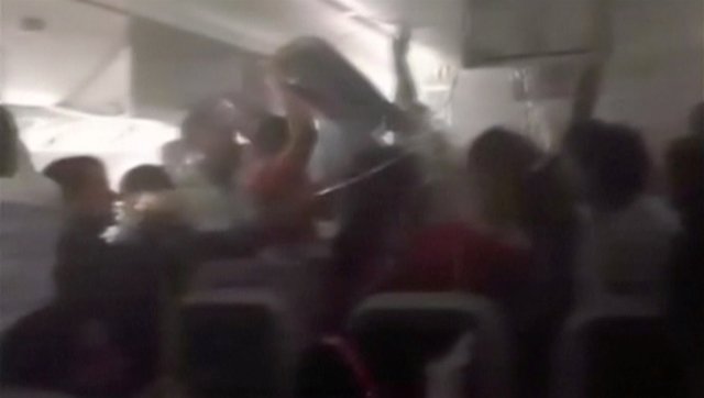 A still image from video shows some passengers in an Emirates Airline airplane trying to access oxygen masks while others trying to retrieve their cabin luggage from overhead lockers, after the plane crash-landed and seconds before the fuselage was engulfed in a ball of flame, in Dubai International Airport, United Arab Emirates August 3, 2016. Video taken August 3, 2016.   Handout via REUTERS TV   ATTENTION EDITORS - THIS PICTURE WAS PROVIDED BY A THIRD PARTY. FOR EDITORIAL USE ONLY. NO RESALES. NO ARCHIVE.