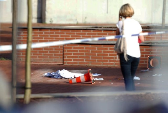 Una mujer se para en el lugar donde un hombre armado con un machete hirió a dos mujeres policías antes de ser abatido a las afueras de la principal estación policial en Charleroi, Bélgica, 6 de agosto de 2016. REUTERS/Francois Lenoir