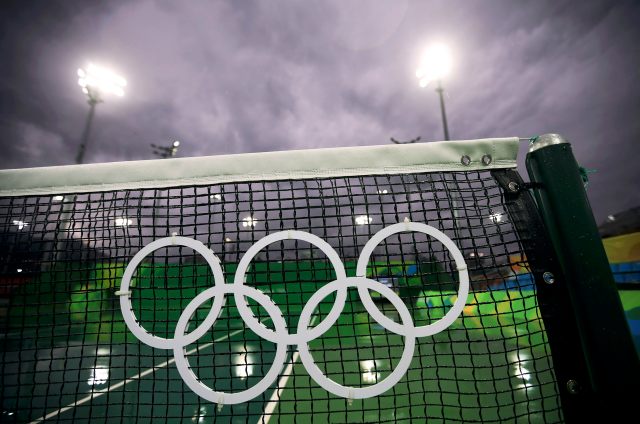 2016 Rio Olympics - Tennis - Olympic Tennis Centre - Rio de Janeiro, Brazil - 10/08/2016. The Olympic rings are seen on a net at a wet and empty court as matches are cancelled for the day session due to rain. REUTERS/Kevin Lamarque FOR EDITORIAL USE ONLY. NOT FOR SALE FOR MARKETING OR ADVERTISING CAMPAIGNS.