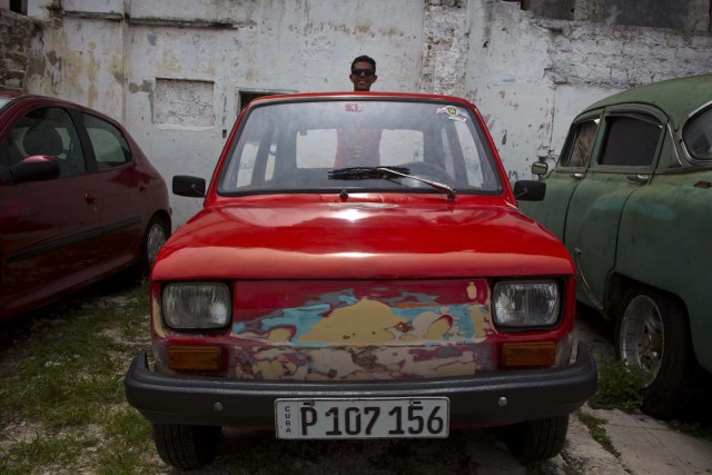 Raúl Seoane posa con un Fiat Polski 126p en un garaje en La Habana, Cuba, el 10 de agosto de 2016. La familia de Raúl Seoane ahorró por años remesas que le enviaron parientes desde España y gastó cerca de 2.000 dólares por un Polski rojo usado y fabricado en 1986. (AP Foto/Ramón Espinosa)