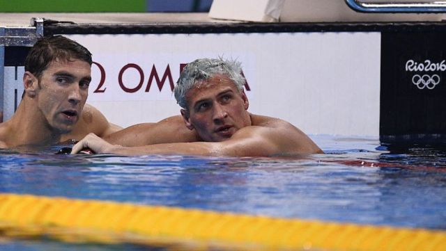 El estadounidense Ryan Lochte, de cabello claro, quien aparece en esta imagen con su compatriota Michael Phelps, fue asaltado por hombres armados en Río de Janeiro. Lochte y tres nadadores más regresaban en taxi a la Villa Olímpica en horas de la madrugada. (Crédito: MARTIN BUREAU/AFP/Getty Images).