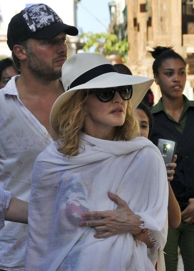 HAB306. LA HABANA (CUBA), 16/08/2016.- La cantante y compositora Madonna camina hoy, martes 16 de agosto del 2016, por una calle de La Habana Vieja en Cuba. Madonna, que hoy cumple 58 años, celebró el día con un paseo por las pintorescas calles del lugar, que también recorrió a bordo de uno de los clásicos coches de época que circulan por la ciudad, conocidos como "almendrones". EFE/ STRINGER