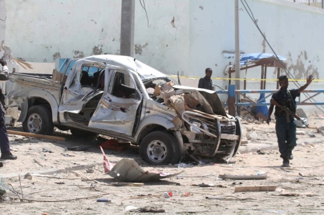 Al menos 10 personas murieron cuando dos coches bomba explotaron delante de la sede del gobierno local en la ciudad de Galkayo en la región semi-autónoma de Puntland en el norte de Somalia el domingo, dijo la policía. En la foto de archivo, un agente de policía da instrucciones al lado de los restos de un coche bomba en mogadiscio el 26 de julio de 2016. REUTERS/Ismail Taxta