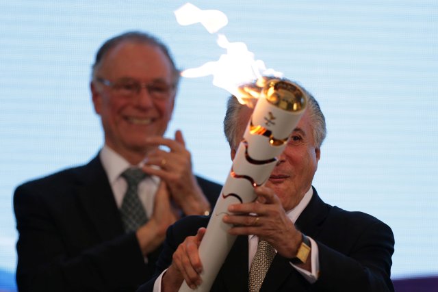 Brazil's interim President Michel Temer (R) holds the torch during the Paralympics Flame torch relay launching ceremony at Planalto Palace in Brasilia, Brazil, August 25, 2016. REUTERS/Ueslei Marcelino