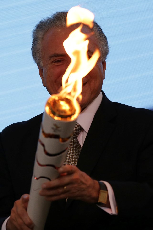 Brazil's interim President Michel Temer holds the torch during the Paralympics Flame torch relay launching ceremony at Planalto Palace in Brasilia, Brazil, August 25, 2016. REUTERS/Ueslei Marcelino