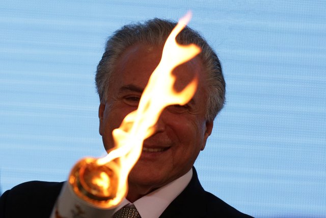 Brazil's interim President Michel Temer holds the torch during the Paralympics Flame torch relay launching ceremony at Planalto Palace in Brasilia, Brazil, August 25, 2016. REUTERS/Ueslei Marcelino