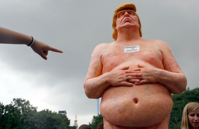 Una mujer señala una estatua del candidato presidencial republicano Donald Trump desnudo, el jueves 18 de agosto de 2016 en Union Square, en Nueva York. La estatua fue retirada por empleados del Departamento de Parques y Recreación de la Ciudad de Nueva York. (AP Foto/Mary Altaffer)