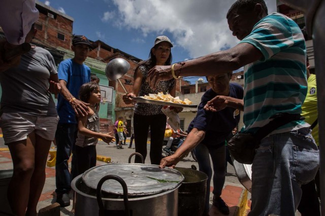 CAR01. CARACAS (VENEZUELA), 10/09/2016.- Un grupo de personas preparan un sancocho hoy, sábado 10 de septiembre del 2016, en la ciudad de Caracas (Venezuela). En el barrio la Unión, ubicado en la favela más grande de América Latina asentada en el este de Caracas, se preparó hoy un gran "sancocho" como se le conoce en Venezuela a la sopa cocinada con varios tipos de verduras y carnes, para alimentar a los vecinos, muchos de ellos con varios días de hambre. EFE/MIGUEL GUTIÉRREZ
