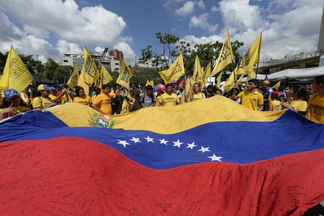 Venezuelan opposition activists march in Caracas on September 16, 2016 demanding to the government to set the date for a recall referendum against President Nicolas Maduro. The Venezuelan opposition's push for a vote to remove President Maduro ran into a roadblock Thursday when authorities announced a delay in setting the date for the final stage in the process. / AFP PHOTO / FEDERICO PARRA