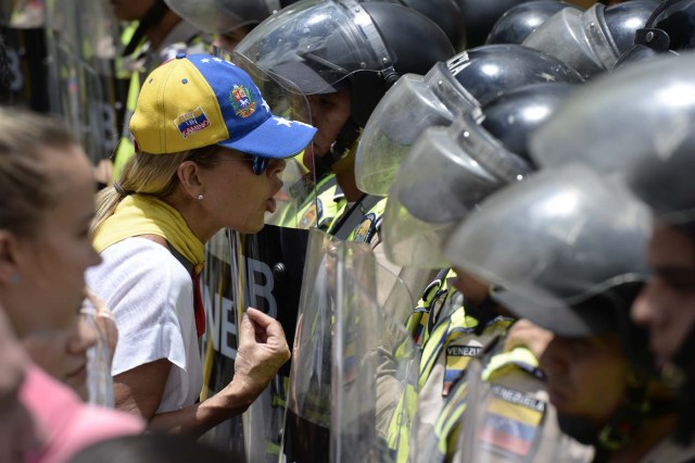 Venezuelan opposition aleader lilian Tintori argues with police during a march in Caracas on September 16, 2016 demanding to the government to set the date for a recall referendum against President Nicolas Maduro. The Venezuelan opposition's push for a vote to remove President Maduro ran into a roadblock Thursday when authorities announced a delay in setting the date for the final stage in the process. / AFP PHOTO / FEDERICO PARRA