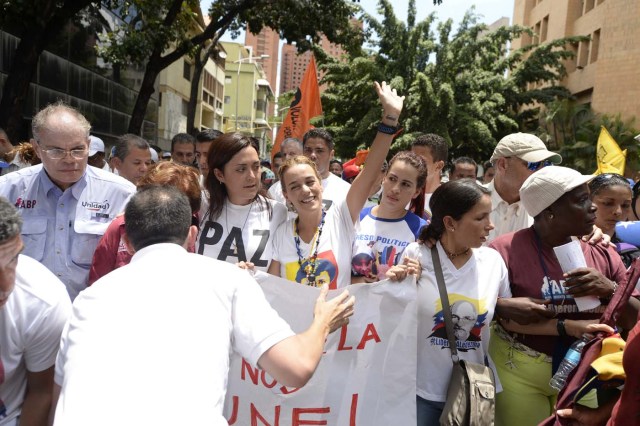 Venezuelan opposition leader Lilian Tintori (C-waving) participates in a march in Caracas on September 16, 2016 demanding to the government to set the date for a recall referendum against President Nicolas Maduro. The Venezuelan opposition's push for a vote to remove President Maduro ran into a roadblock Thursday when authorities announced a delay in setting the date for the final stage in the process. / AFP PHOTO / FEDERICO PARRA