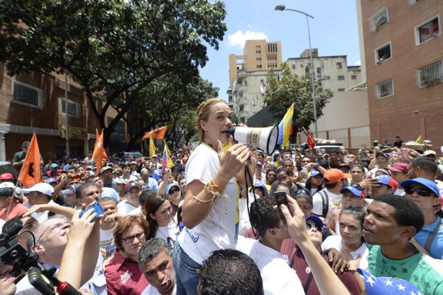 Venezuelan opposition leader Lilian Tintori (C) delivers a speech during a march in Caracas on September 16, 2016 demanding to the government to set the date for a recall referendum against President Nicolas Maduro. The Venezuelan opposition's push for a vote to remove President Maduro ran into a roadblock Thursday when authorities announced a delay in setting the date for the final stage in the process. / AFP PHOTO / FEDERICO PARRA
